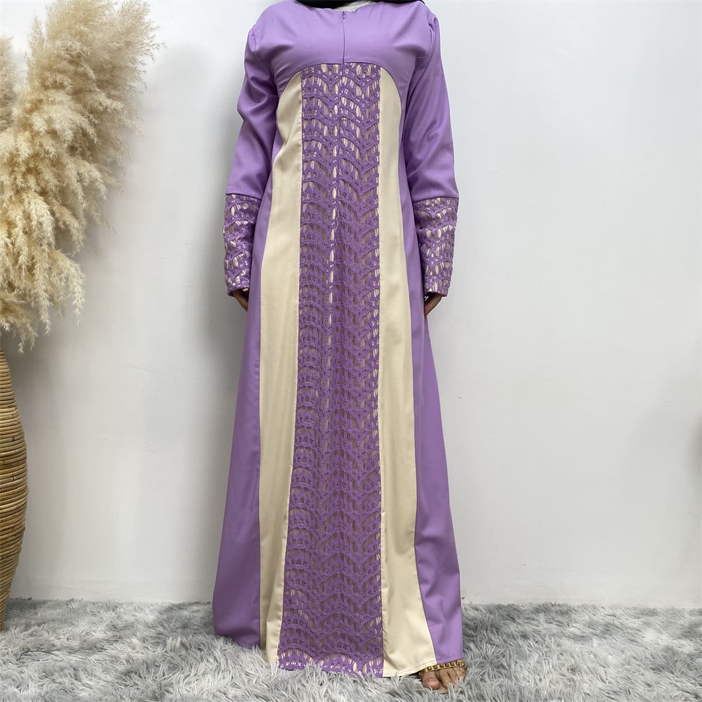 Abito lungo elegante viola e beige con dettagli in pizzo, sfondo bianco, tappeto grigio, pianta decorativa a sinistra. Moda femminile, abbigliamento formale.