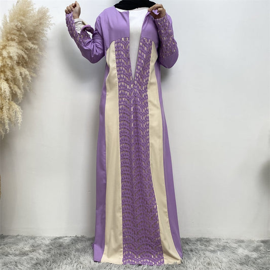 Abaya viola e crema con dettagli in pizzo, indossata da una persona su sfondo bianco. Moda islamica elegante, abbigliamento tradizionale femminile.