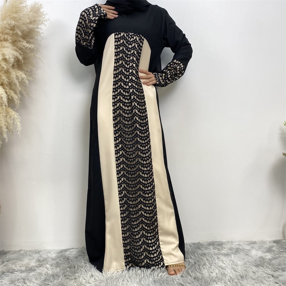 Abito lungo nero e beige con dettagli a motivo geometrico, maniche lunghe, su sfondo bianco. Moda femminile elegante, abbigliamento tradizionale.