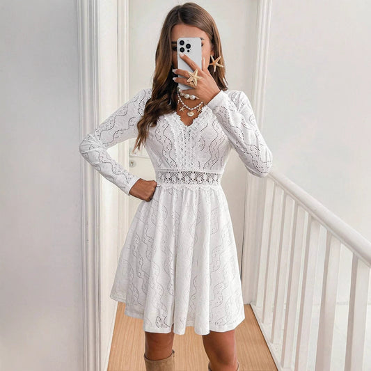 Donna in abito bianco di pizzo, maniche lunghe, scatta selfie con smartphone. Moda elegante, stile casual, accessori conchiglia.