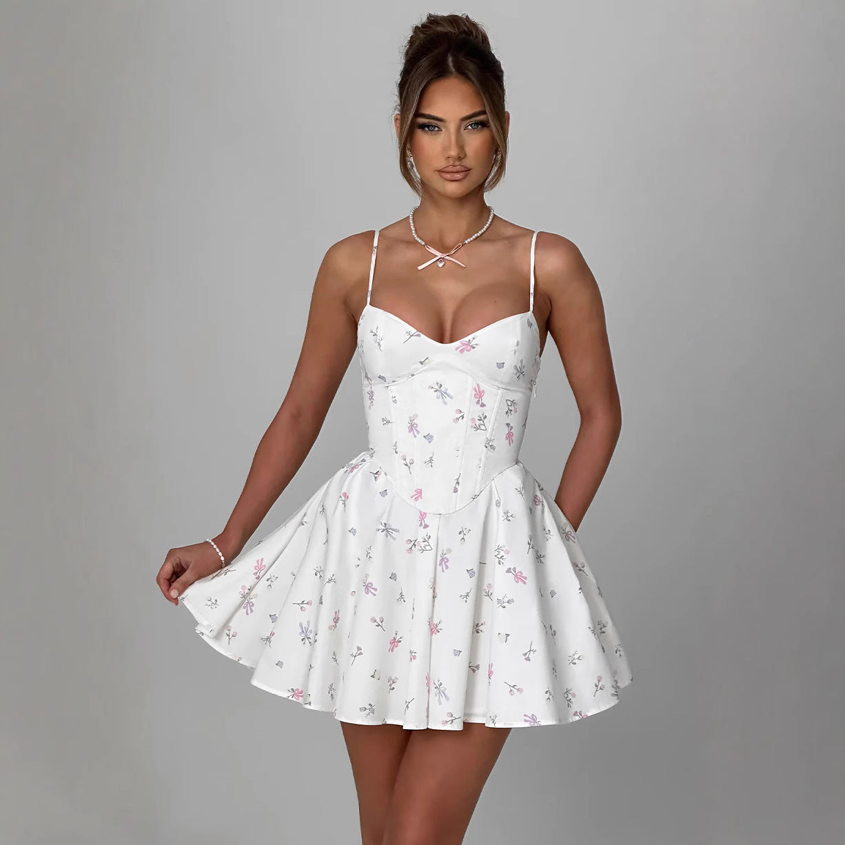 Abito estivo bianco con stampa floreale, spalline sottili e corpetto aderente. Moda donna elegante, stile casual chic, tendenze abbigliamento 2023.