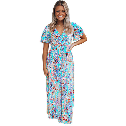 Donna sorridente con abito lungo floreale multicolore, maniche corte, sfondo bianco. Moda estiva, abbigliamento femminile elegante.