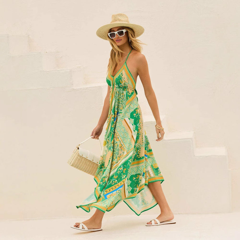 Donna con abito estivo verde e giallo, cappello di paglia, occhiali da sole bianchi, borsa intrecciata, sandali bianchi, su scala bianca.
