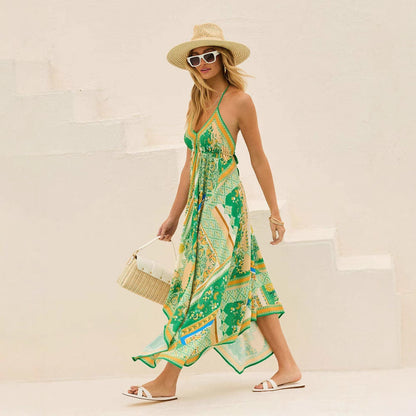 Donna con abito estivo verde e giallo, cappello di paglia, occhiali da sole bianchi, borsa intrecciata, sandali bianchi, su scala bianca.