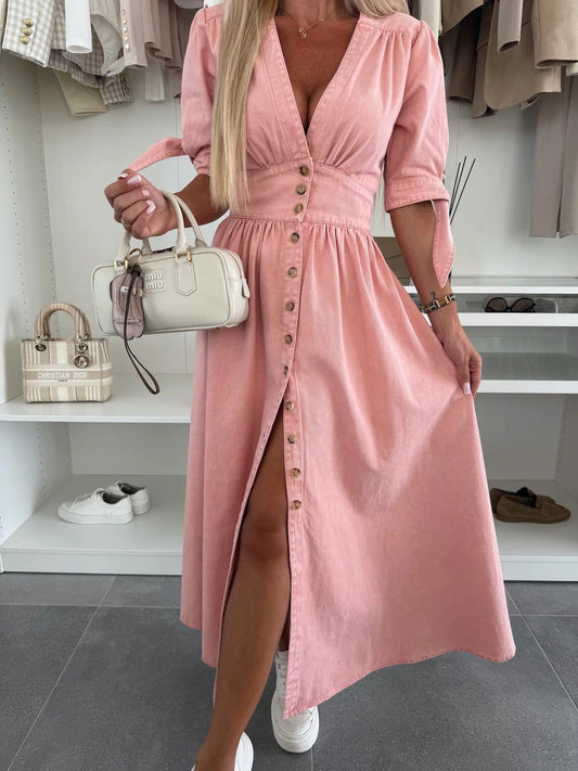 Donna in abito rosa con bottoni, borsa bianca a mano, scarpe bianche sullo sfondo. Moda femminile, abbigliamento estivo elegante.