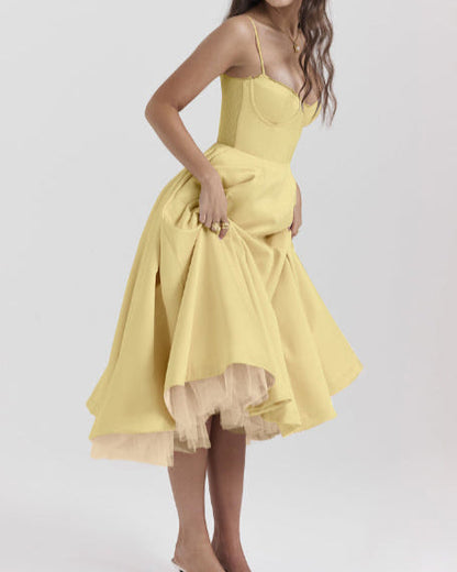 Abito giallo elegante con corpetto aderente e gonna ampia, indossato da una donna. Moda femminile, abbigliamento estivo, stile sofisticato.