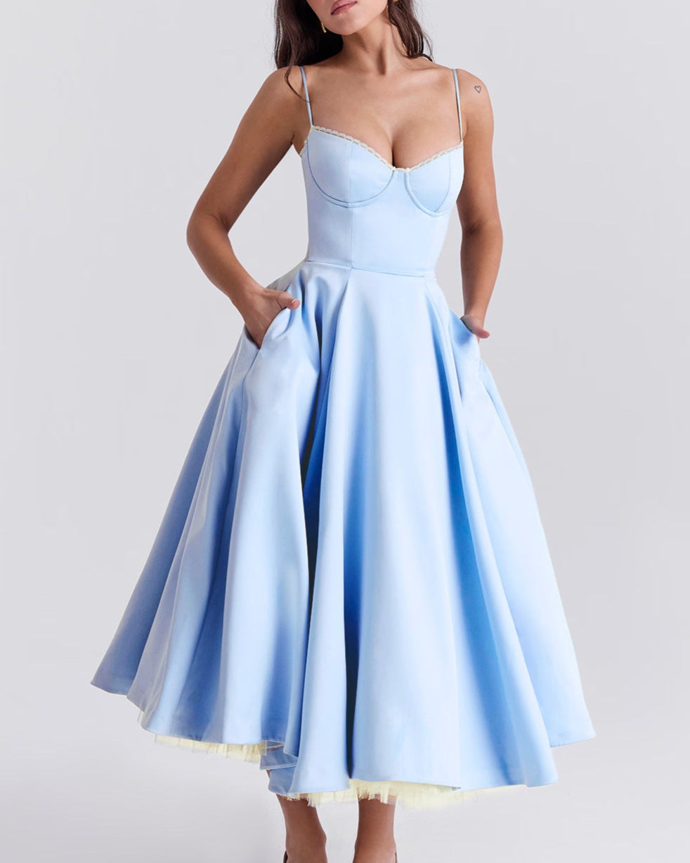 Abito elegante azzurro con spalline sottili e gonna ampia, indossato da una donna. Moda femminile, abbigliamento da sera, stile sofisticato.