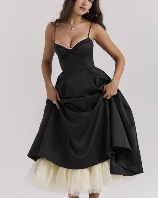 Abito nero elegante con spalline sottili e sottogonna in tulle bianco, indossato da una donna. Moda femminile, abbigliamento da sera.