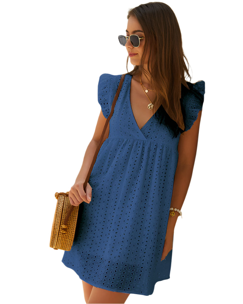 Donna con abito blu traforato, occhiali da sole e borsa a tracolla in paglia. Stile estivo elegante, moda femminile casual.