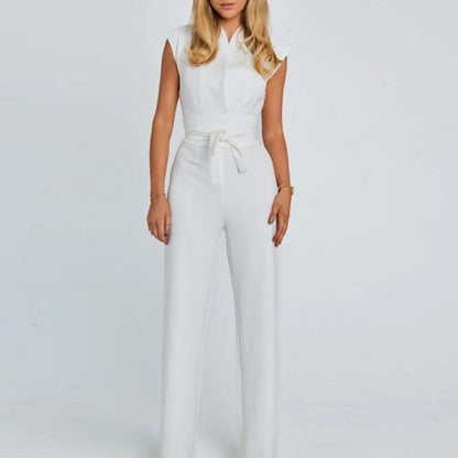 Donna in tuta bianca elegante, senza maniche, con cintura in vita. Moda femminile, abbigliamento estivo, stile minimalista. Sfondo bianco.