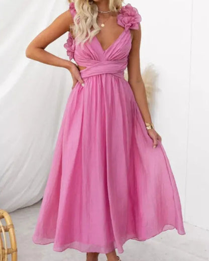 Donna in abito lungo rosa con spalline a fiori, posa elegante. Moda estiva, abbigliamento femminile, stile chic. Sfondo bianco minimalista.