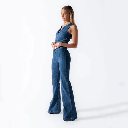 Donna in tuta di jeans a zampa, posa su sfondo bianco. Moda femminile, abbigliamento casual, stile anni '70, eleganza denim.
