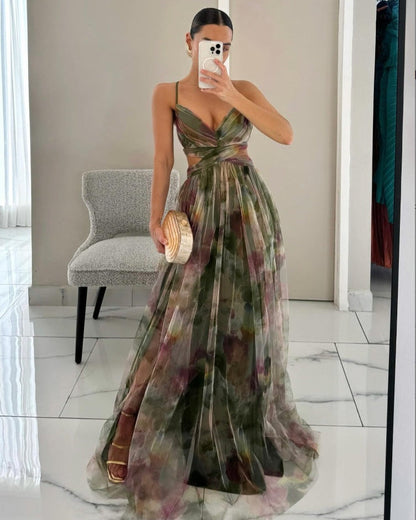 Donna in abito lungo floreale verde, scollatura a V, posa davanti a uno specchio. Elegante look da sera, moda femminile, tendenze abbigliamento 2023.