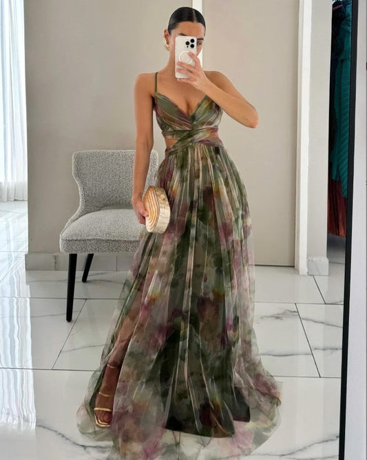 Donna in abito lungo floreale verde, scollatura a V, posa davanti a uno specchio. Elegante look da sera, moda femminile, tendenze abbigliamento 2023.