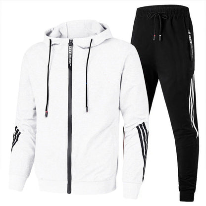 Tuta sportiva uomo, giacca bianca con cappuccio e pantaloni neri, design moderno, strisce laterali, abbigliamento casual e fitness.