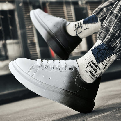 Scarpe da ginnastica bianche e nere su sfondo urbano, indossate con calzini stampati e pantaloni a quadri. Moda streetwear, sneakers casual uomo.