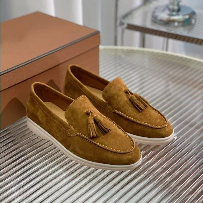 Mocassini in pelle scamosciata marrone con nappine, suola bianca, su tavolo metallico. Scarpe eleganti uomo, moda calzature, stile casual chic.
