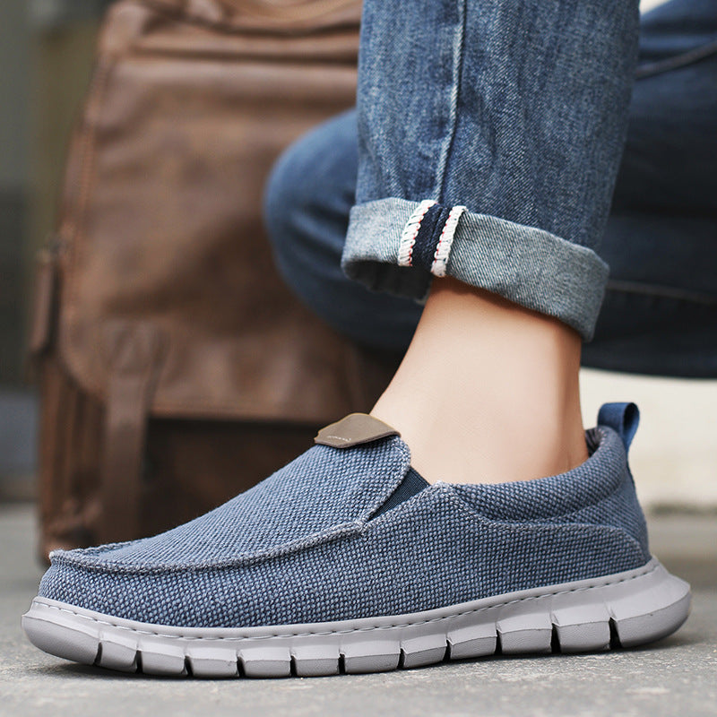 Scarpe casual uomo in tessuto blu, suola in gomma bianca, indossate con jeans. Design comodo e moderno, perfette per look quotidiani e urbani.