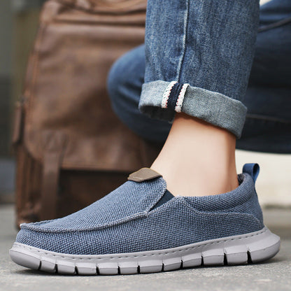 Scarpe casual uomo in tessuto blu, suola in gomma bianca, indossate con jeans. Design comodo e moderno, perfette per look quotidiani e urbani.