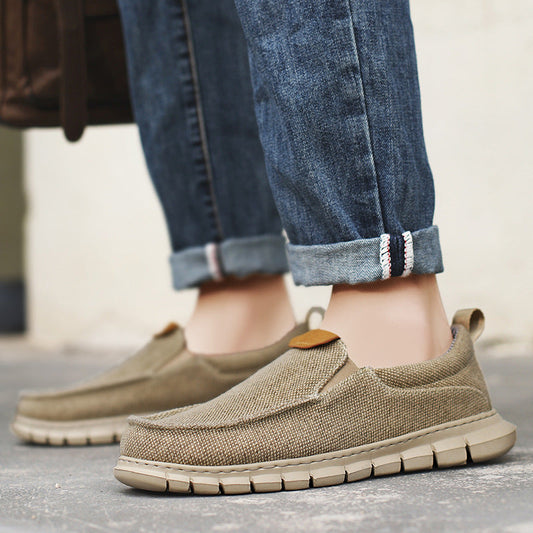 Scarpe casual uomo in tela beige, suola in gomma, abbinate a jeans arrotolati. Calzature comode e alla moda per look quotidiani.