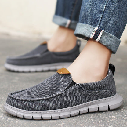 Scarpe casual uomo in tessuto grigio, suola in gomma bianca, indossate con jeans. Scarpe comode e alla moda per uso quotidiano.