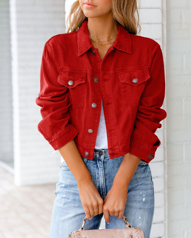 Giacca rossa in denim su donna, abbinata a jeans chiari e top bianco. Moda casual femminile, stile urbano, tendenze abbigliamento autunnale.
