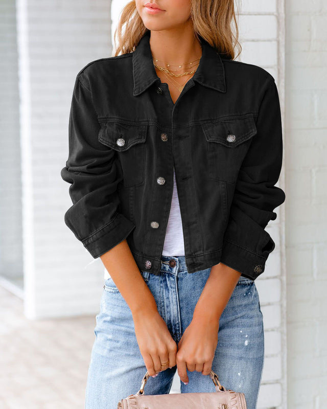 Donna con giacca di jeans nera, camicia bianca e jeans chiari, in posa casual. Moda femminile, abbigliamento casual chic, tendenze autunno.