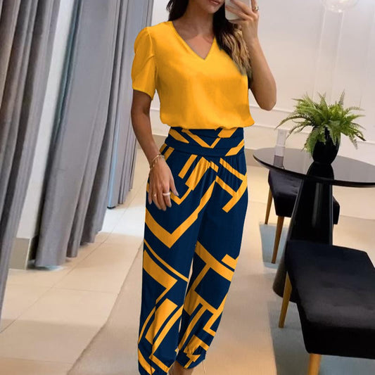 Donna in abbigliamento elegante: maglia gialla e pantaloni blu con motivi geometrici gialli. Moda femminile, stile moderno, outfit casual chic.