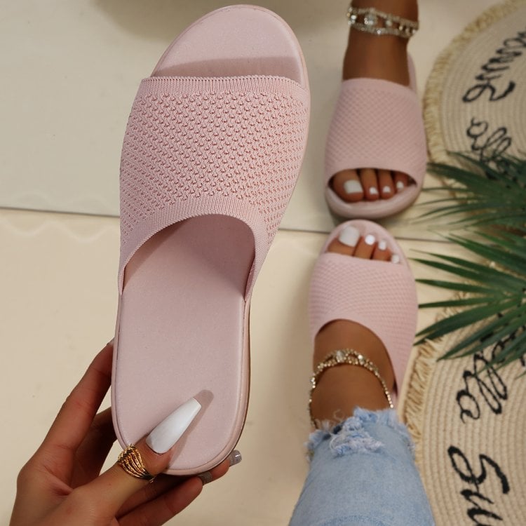 Sandali rosa intrecciati da donna, indossati con jeans strappati e cavigliere dorate. Moda estiva, calzature casual eleganti.