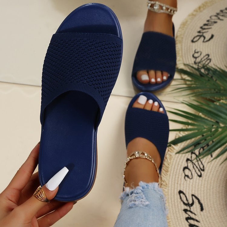 Sandali blu intrecciati da donna, indossati con jeans strappati e cavigliere dorate. Moda estiva, calzature casual eleganti.