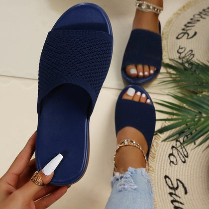 Sandali blu intrecciati da donna, indossati con jeans strappati e cavigliere dorate. Moda estiva, calzature casual eleganti.