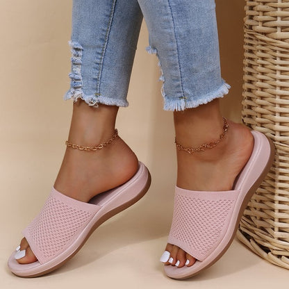 Jeans strappati e sandali rosa con zeppa, indossati da una persona con cavigliere dorate. Scarpe estive moda donna, stile casual chic.