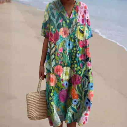 Abito estivo floreale colorato su spiaggia, donna con borsa di paglia. Moda mare, abbigliamento leggero, stile boho chic.