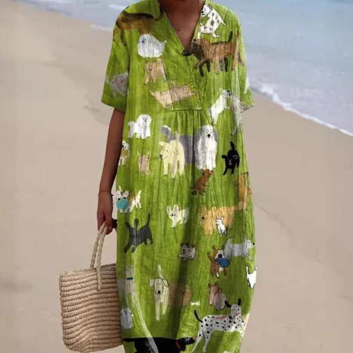 Donna in abito verde con stampa di cani, cammina su una spiaggia. Moda estiva, abbigliamento casual, vestito lungo, borsa di paglia.