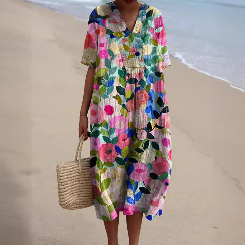 Abito estivo floreale colorato su spiaggia sabbiosa, donna con borsa di paglia. Moda mare, abbigliamento estivo, vestito casual.