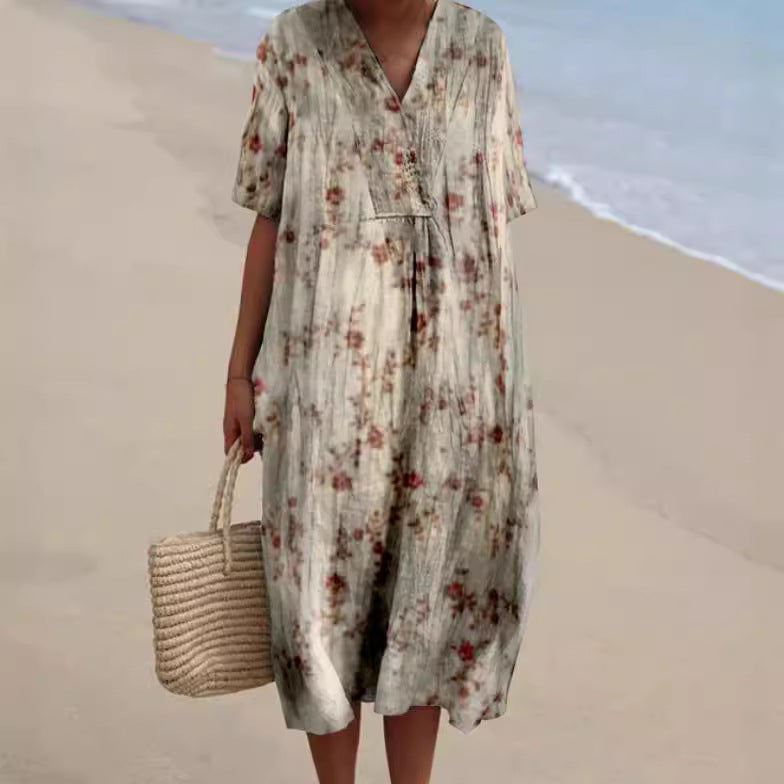 Abito estivo floreale lungo, stile boho, indossato su spiaggia sabbiosa. Vestito casual con borsa di paglia, moda mare donna.