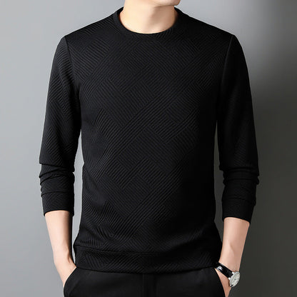 Maglia nera a maniche lunghe con motivo geometrico, indossata da una persona su sfondo grigio. Moda uomo, abbigliamento casual elegante.