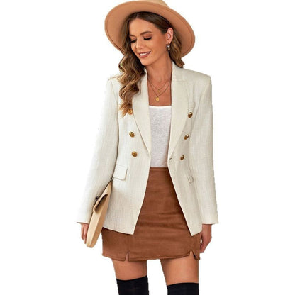Donna con cappello beige, blazer bianco a doppiopetto, top bianco, gonna marrone e stivali neri. Moda autunnale elegante e casual.