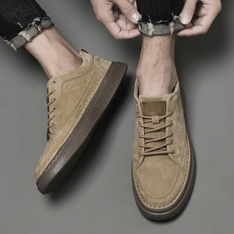 Scarpe da uomo in pelle scamosciata beige, suola marrone, indossate con jeans arrotolati. Stile casual, moda maschile, calzature eleganti.