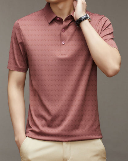Uomo con polo rosa a maniche corte, motivo geometrico, orologio al polso, sfondo neutro. Moda maschile, abbigliamento casual elegante.