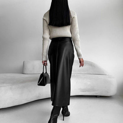 Donna di spalle con maglione bianco, gonna lunga in pelle nera, stivali alti e borsa nera. Design minimalista, moda autunnale elegante.