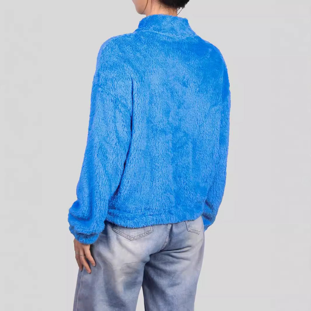 Giacca in pile blu elettrico, morbida e calda, indossata da una persona di spalle. Perfetta per l'inverno, moda casual, comfort e stile.