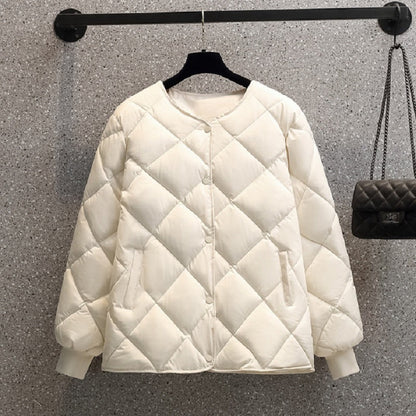 Giacca trapuntata bianca appesa su gruccia, design a rombi, maniche lunghe, tasche laterali, sfondo grigio, moda invernale elegante.