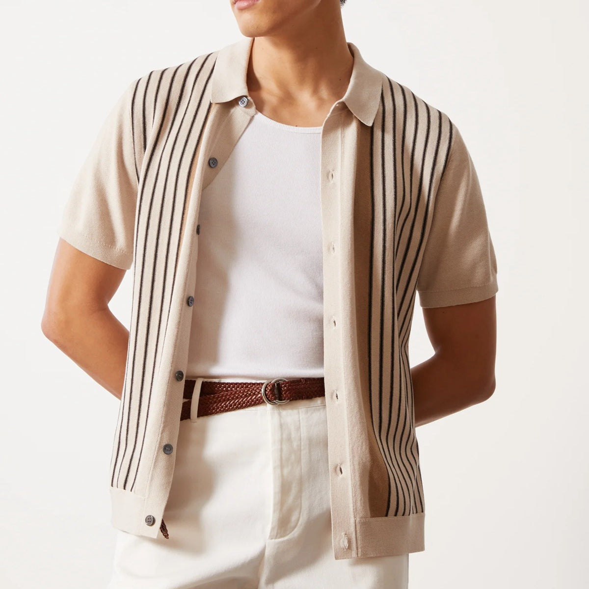 Camicia beige a righe verticali nere, maniche corte, indossata sopra una maglietta bianca. Stile casual elegante, moda uomo estiva.