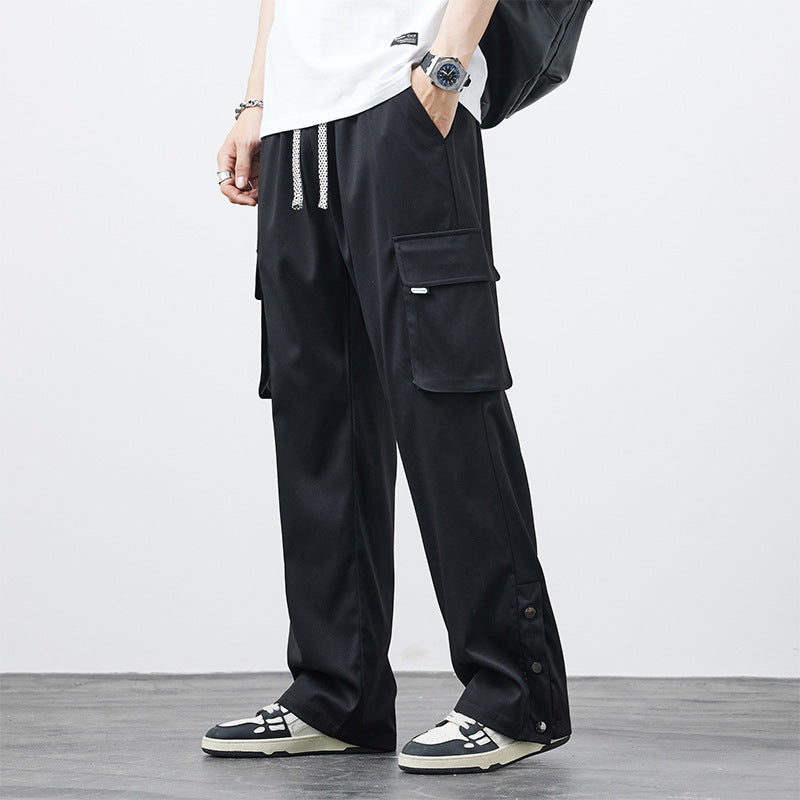 Pantaloni cargo neri da uomo, tasche multiple, abbinati a sneakers bianche e nere. Stile casual, moda urbana, abbigliamento streetwear.