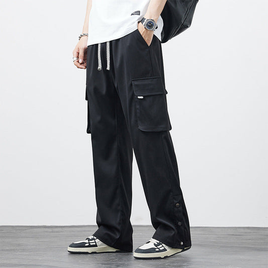 Pantaloni cargo neri da uomo, tasche multiple, abbinati a sneakers bianche e nere. Stile casual, moda urbana, abbigliamento streetwear.
