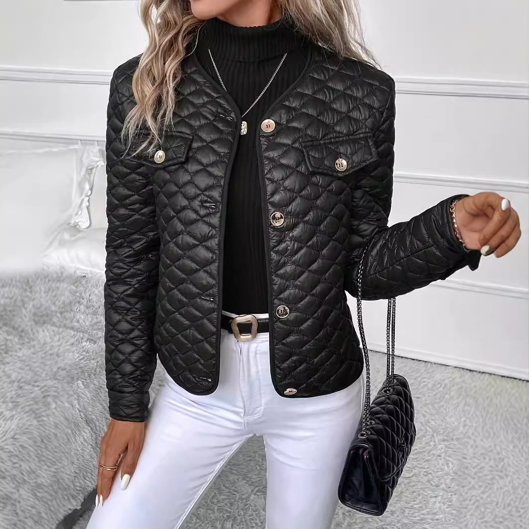 Donna con giacca trapuntata nera, maglione nero a collo alto, jeans bianchi e borsa a tracolla nera. Moda autunnale elegante e chic.