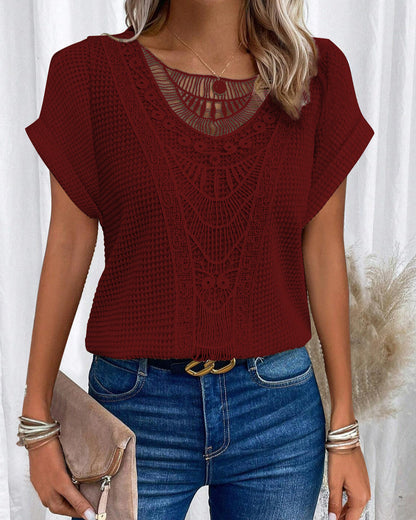 Donna con maglia rossa in pizzo, jeans blu, cintura nera e borsa beige. Stile casual elegante, moda femminile, abbigliamento estivo.