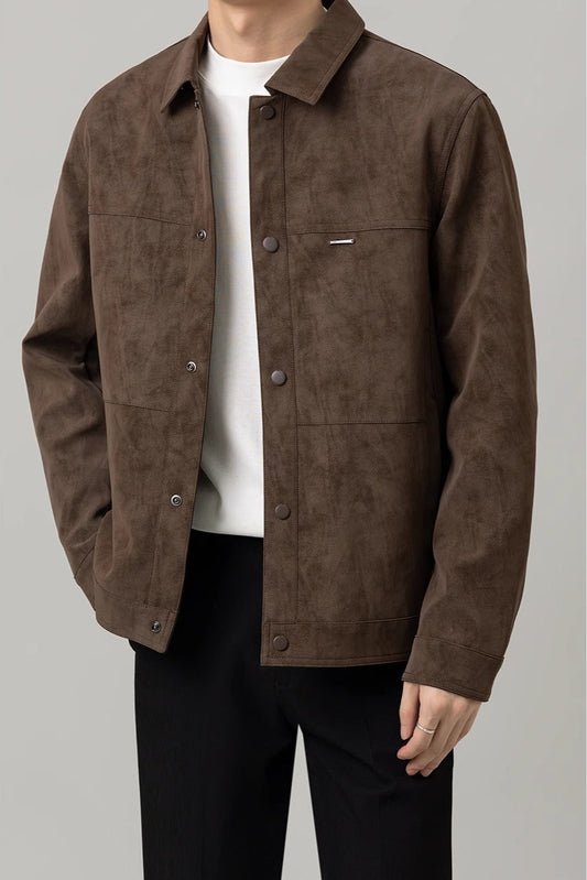 Giacca marrone in pelle scamosciata da uomo, stile casual, con bottoni frontali e tasche, indossata su maglietta bianca e pantaloni neri.