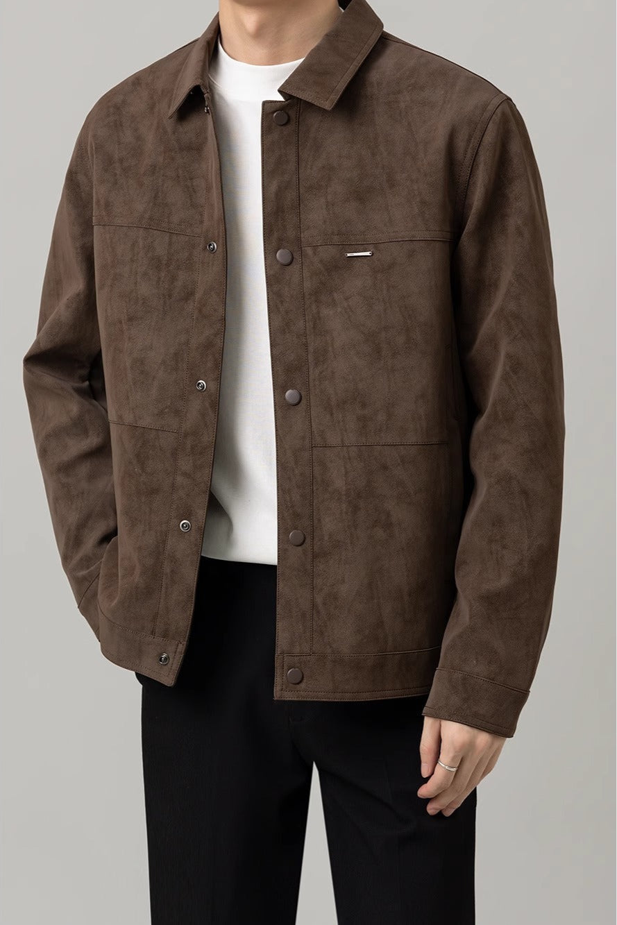 Giacca marrone in pelle scamosciata da uomo, stile casual, abbinata a maglietta bianca e pantaloni neri. Moda autunnale elegante e moderna.